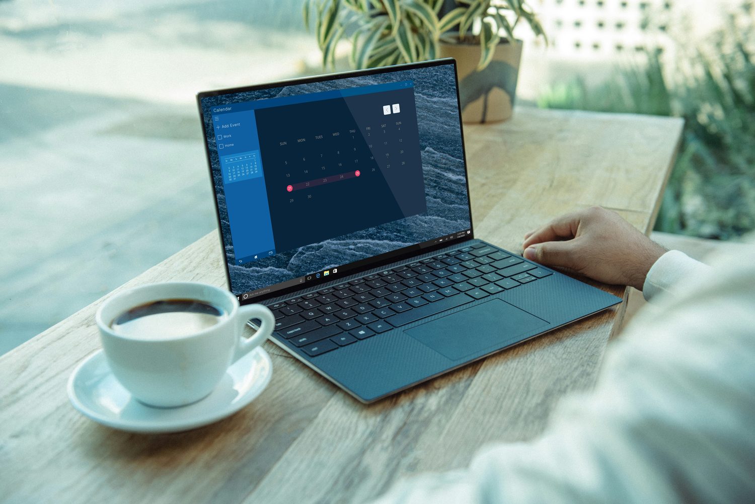 A hand resting on a laptop trackpad with a month of dated entries shown on screen